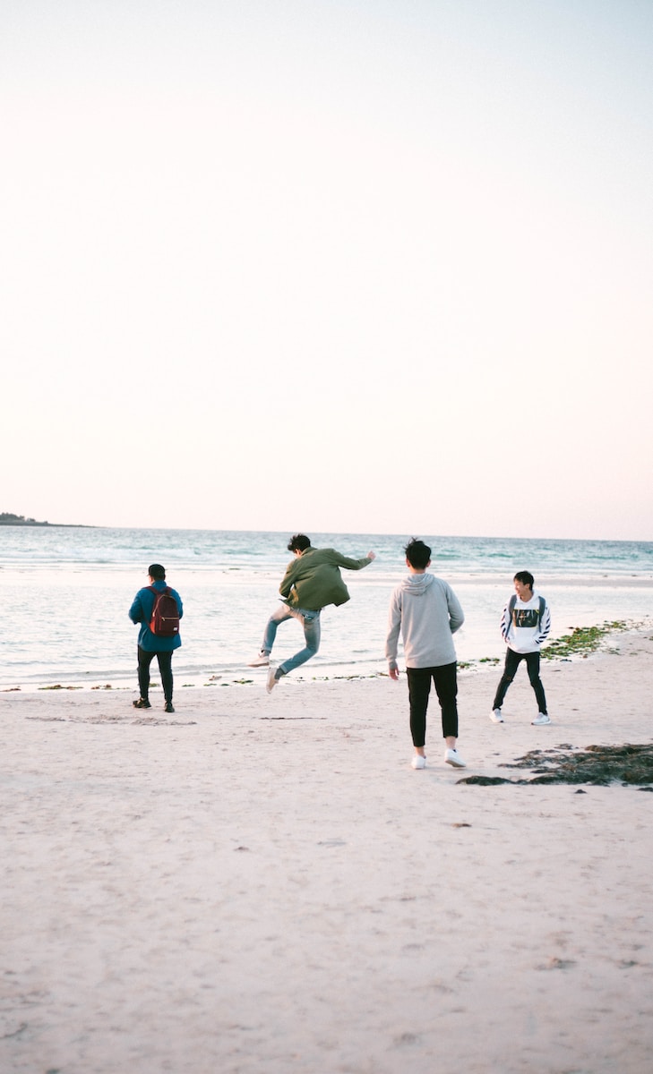 four persons near shore at daytime